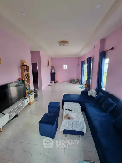 Spacious living room with modern blue sofa and entertainment center in a stylish home.