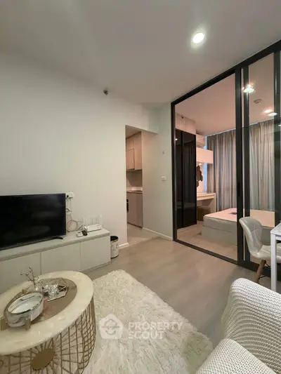 Modern living room with open view to bedroom, featuring stylish decor and cozy ambiance.