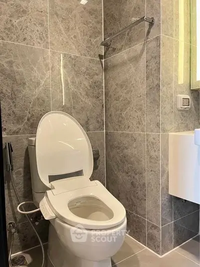 Modern bathroom with sleek marble tiles and high-tech toilet