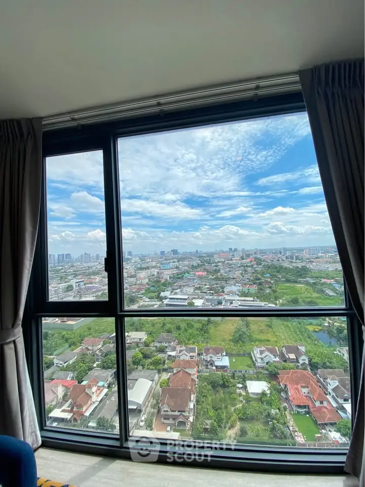 Stunning cityscape view from high-rise apartment window with clear skies.