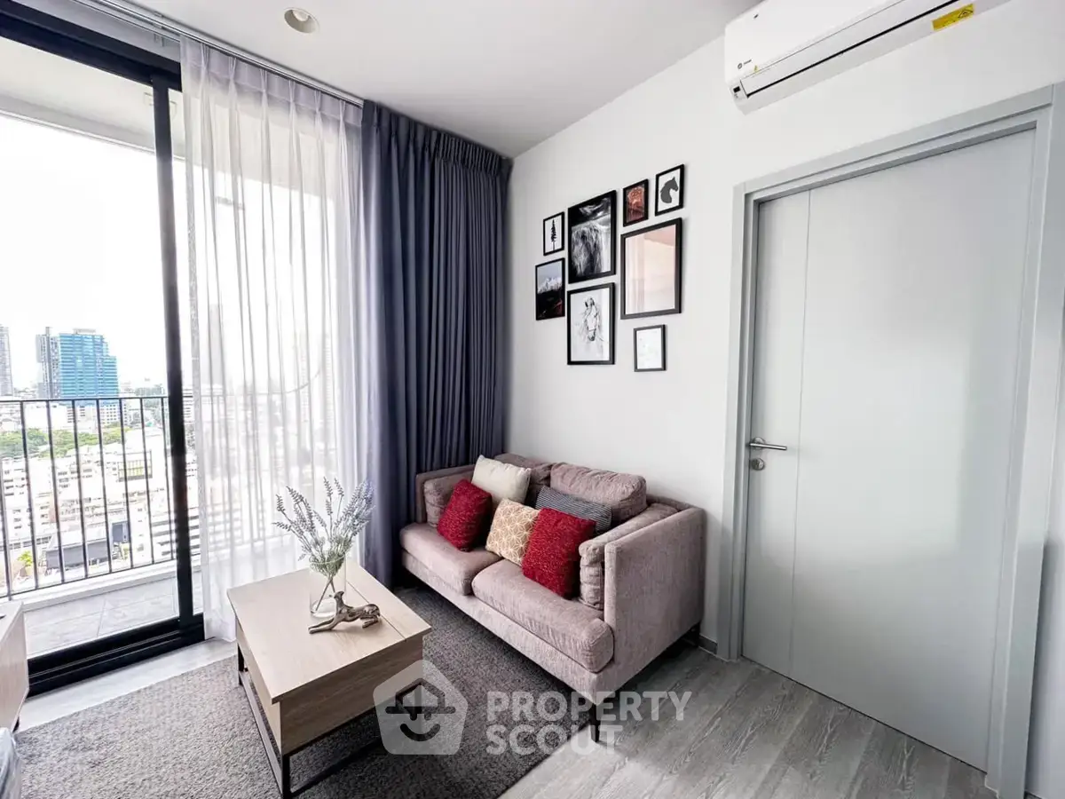 Modern living room with balcony view, cozy sofa, and stylish decor in a high-rise apartment.
