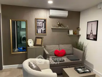 Cozy living room with modern decor and air conditioning, featuring a stylish sofa and elegant wall art.
