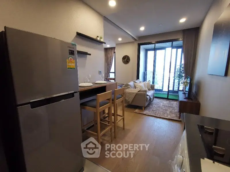 Modern open-layout kitchen and living room with balcony view in stylish apartment.