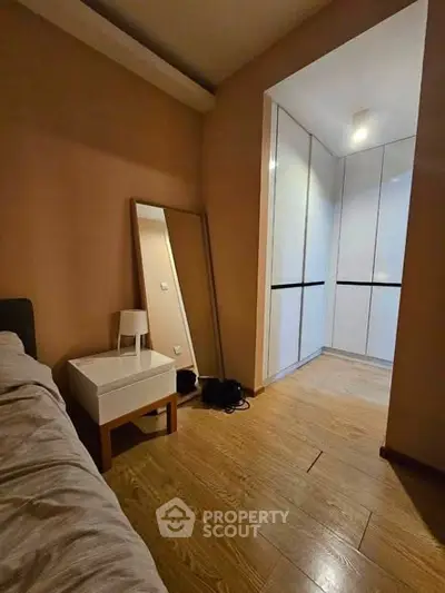 Cozy bedroom with wooden flooring and a spacious walk-in closet