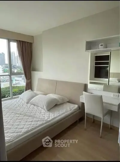 Modern bedroom with large window and city view, featuring a cozy bed and sleek vanity desk.