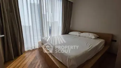 Spacious bedroom with natural light and modern wooden flooring