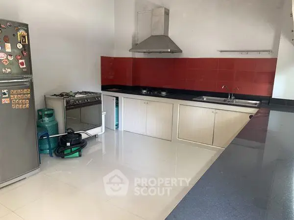 Modern kitchen with red backsplash and stainless steel appliances