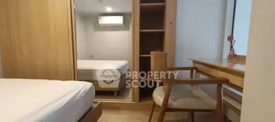 Cozy bedroom with wooden furniture and mirrored wardrobe, perfect for relaxation and comfort.