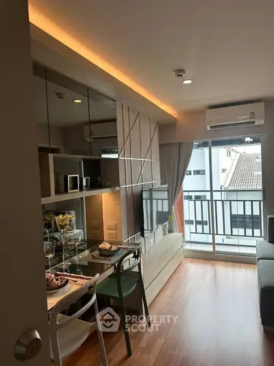 Modern living room with balcony, stylish decor and ample natural light.