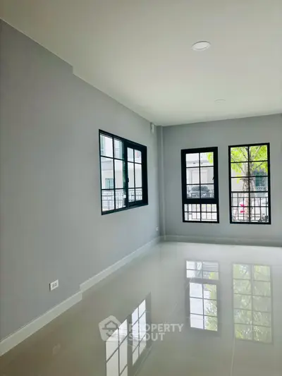 Spacious modern living room with large windows and glossy tile flooring