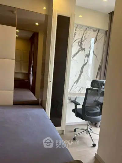 Modern bedroom with stylish study area and marble accent wall, perfect for urban living.