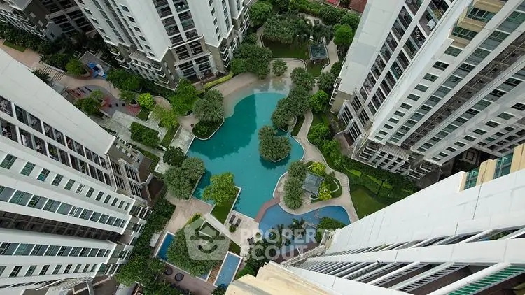 Stunning aerial view of modern residential complex with lush gardens and inviting pool area.