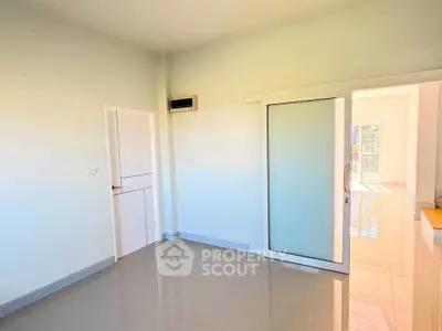 Bright empty room with sliding glass door and glossy tiled floor