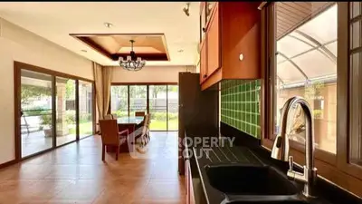 Spacious open-layout kitchen and dining area with garden view, featuring modern fixtures and elegant design.