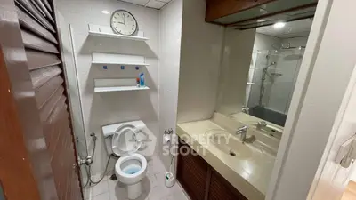 Compact bathroom with modern fixtures and wall-mounted shelves