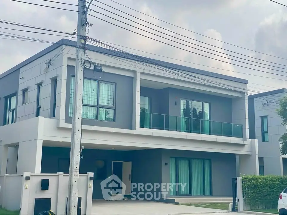 Modern two-story house with sleek design and spacious balcony in a serene neighborhood.