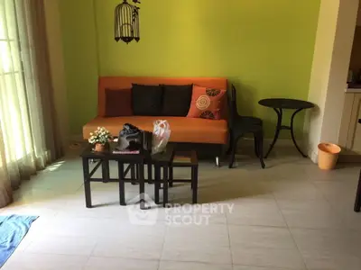 Cozy living room with vibrant orange sofa and stylish decor