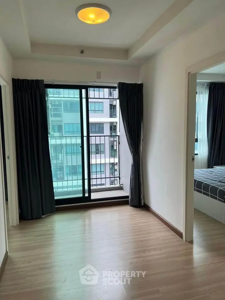 Spacious apartment with large windows and balcony access, featuring modern interiors and ample natural light.