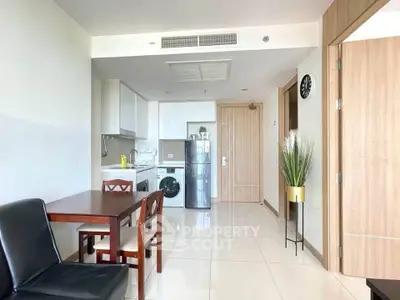 Modern apartment interior with kitchen and dining area featuring sleek appliances and stylish decor.