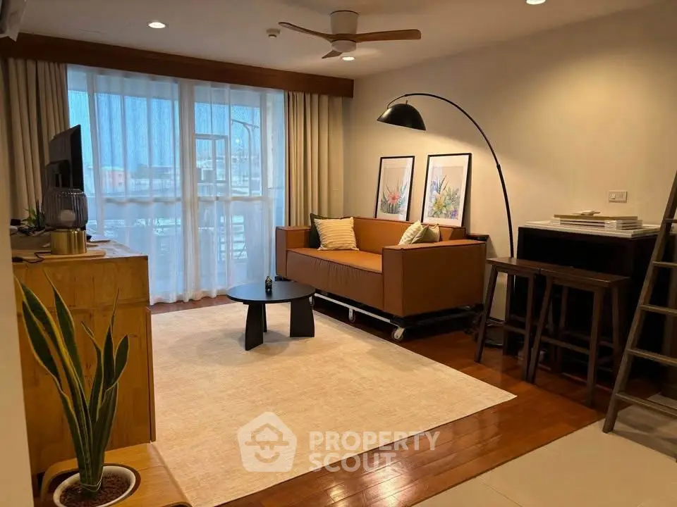 Stylish living room with modern decor and natural light, featuring a cozy sofa and elegant furnishings.