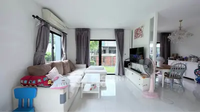 Spacious living room with modern decor, large windows, and cozy seating area, perfect for family gatherings.