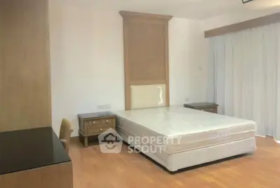 Spacious bedroom with modern furniture and natural light, perfect for comfortable living.