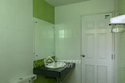 Modern bathroom with sleek sink and green tile accents