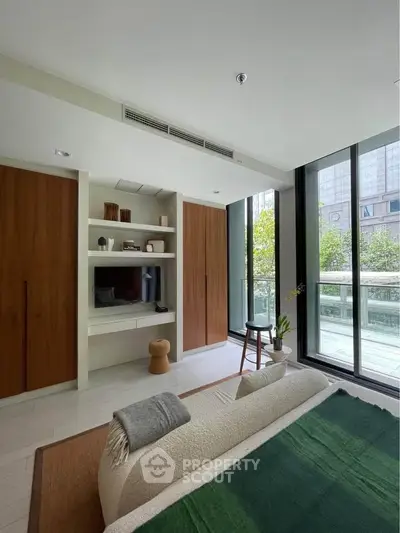 Modern bedroom with large windows and balcony access in urban apartment