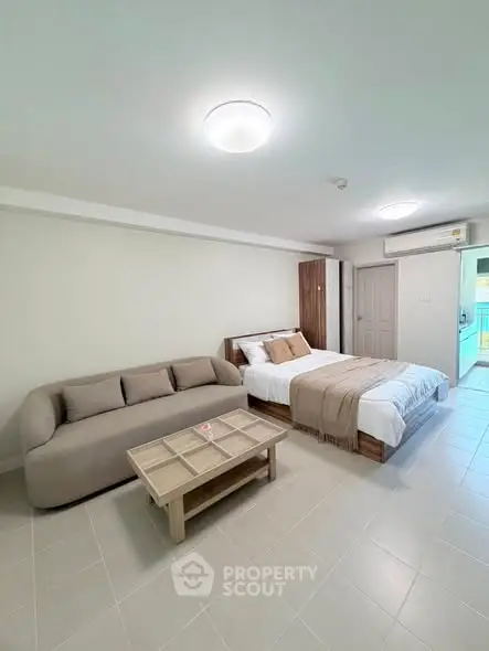 Modern bedroom with cozy sofa and stylish decor in a bright, spacious apartment.