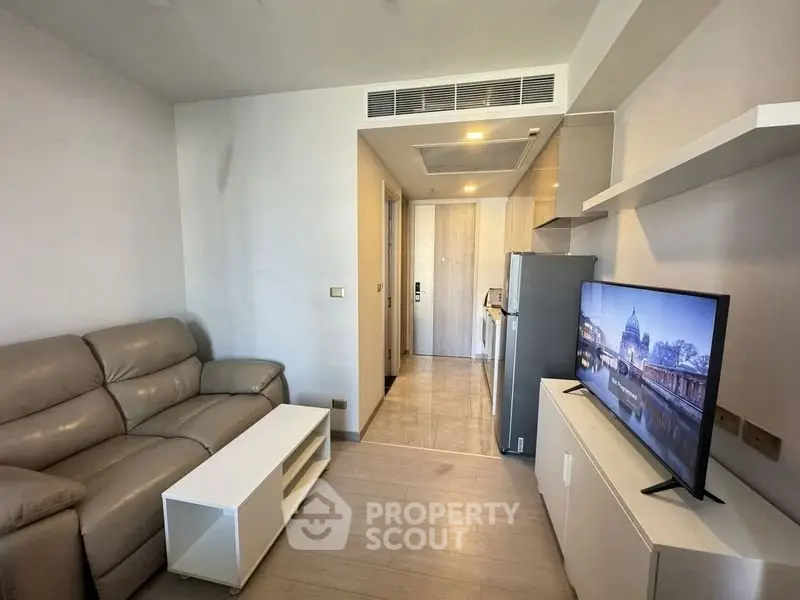 Modern living room with sleek furniture and flat-screen TV in cozy apartment