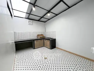 Modern kitchen with open layout and stylish black and white tile flooring.