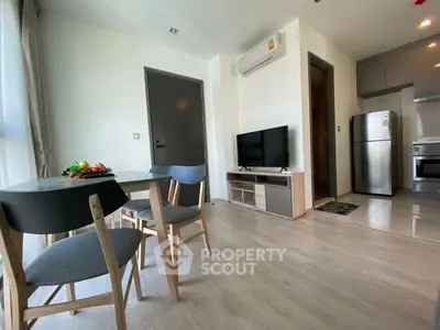 Modern open-plan living room with dining area and kitchen in a stylish apartment.