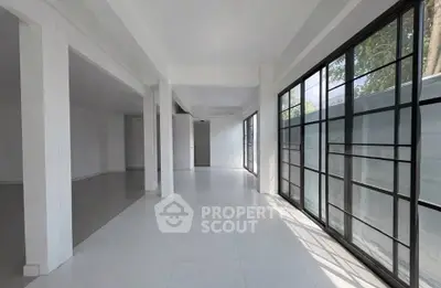 Spacious open-plan interior with large windows and modern design, perfect for natural light lovers.