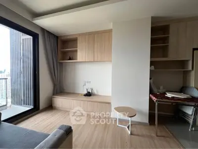 Modern living room with wooden flooring and built-in storage, featuring a large window with city view.