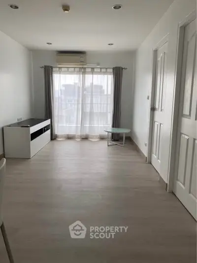 Spacious minimalist living room with large window and modern decor