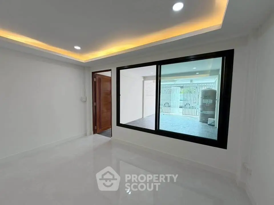 Modern minimalist living room with large window and recessed lighting