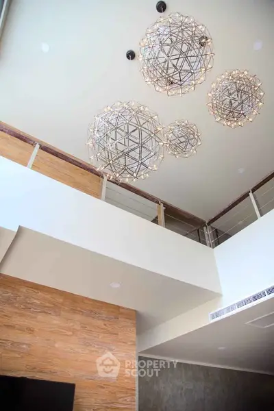 Modern interior with unique geometric chandeliers and high ceiling design.