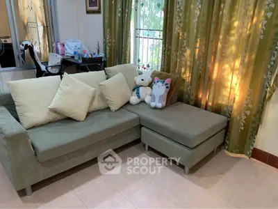 Cozy living room with green sofa and plush toys, perfect for relaxation.