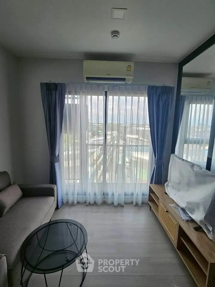 Modern living room with large window and city view, featuring a cozy sofa and sleek TV stand.