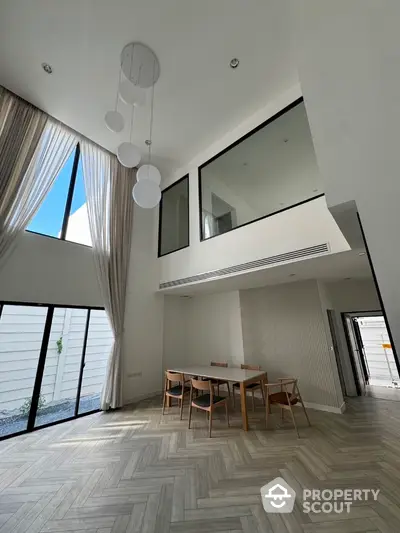 Spacious modern dining area with high ceilings and large windows