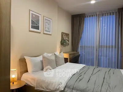 Cozy bedroom with modern decor and large window offering stunning city views.
