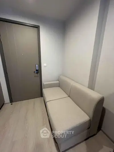 Cozy entryway with modern sofa and sleek door, perfect for welcoming guests.