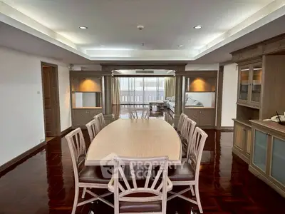 Spacious dining area with elegant wooden furniture and open layout leading to a cozy living room.