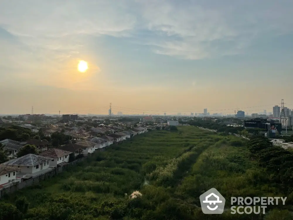 Stunning panoramic view of suburban landscape at sunset, showcasing vast greenery and distant city skyline.