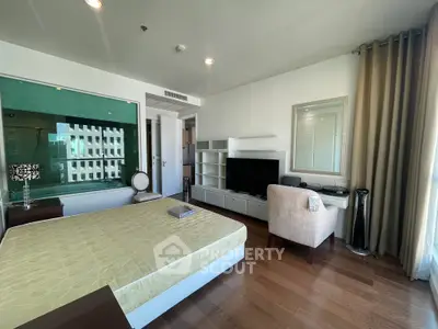 Modern bedroom with stylish decor and large window offering ample natural light.