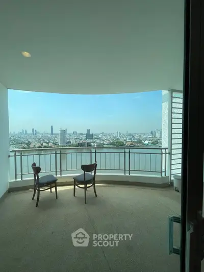 Stunning high-rise balcony with panoramic city and river views, perfect for relaxation.
