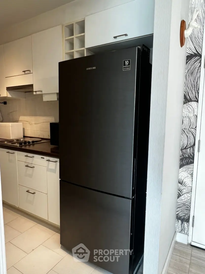 Modern kitchen with sleek black fridge and white cabinetry