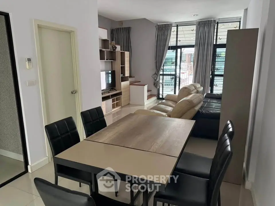 Modern living room with dining area and stylish furniture in a bright, open layout.