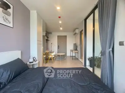 Modern studio apartment with sleek design and balcony access, featuring stylish furniture and ample natural light.