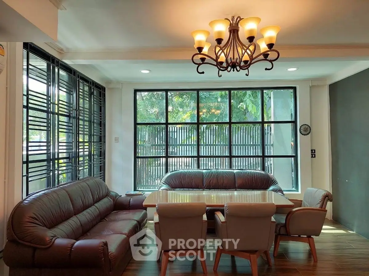 Spacious living room with elegant chandelier and large windows